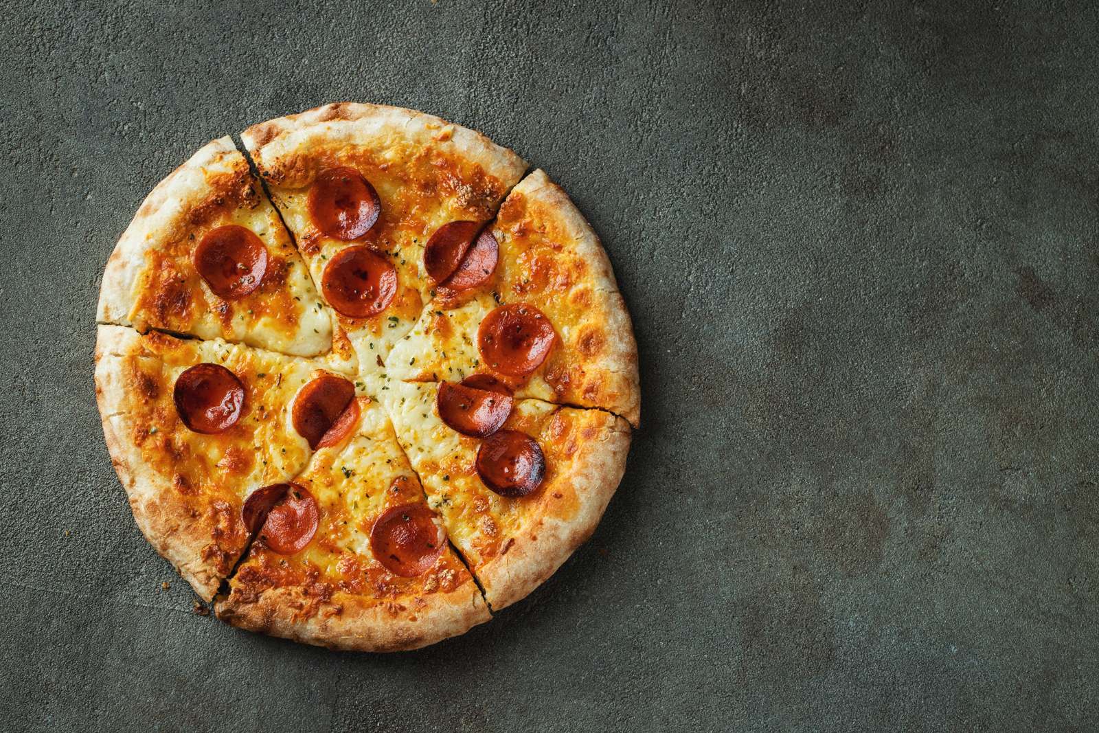 A pepperoni pizza cut into slices